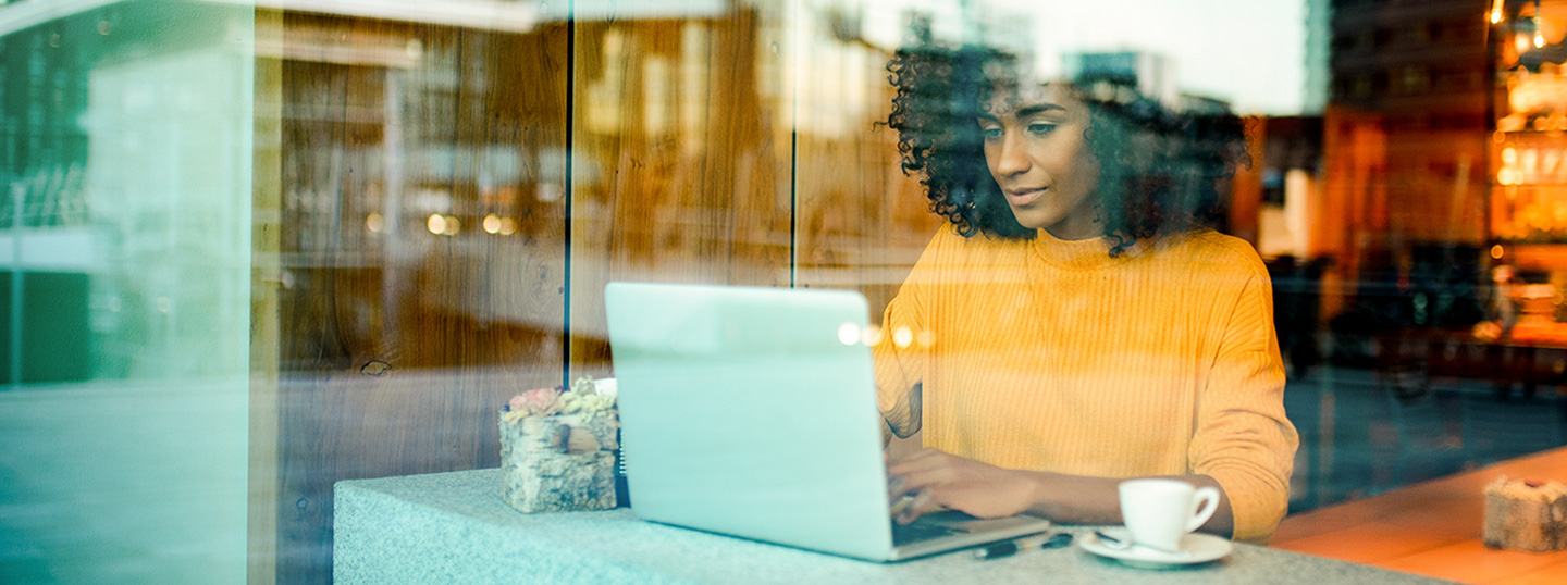Woman sitting in cafe in front of a laptop