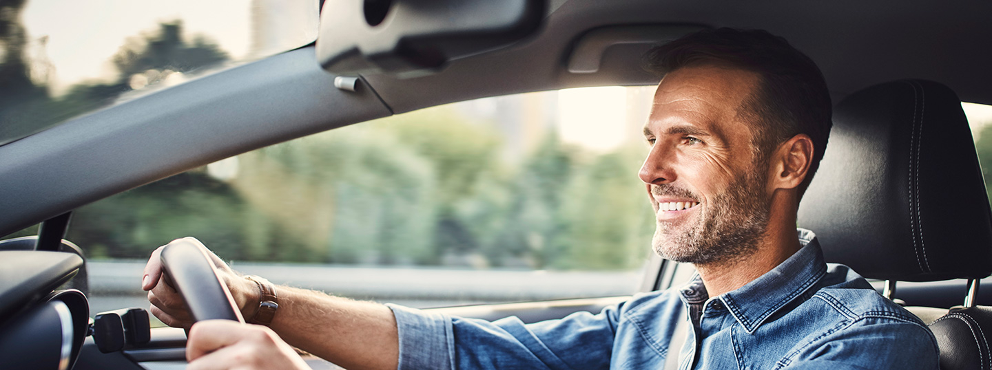 Man smiling while driving his car